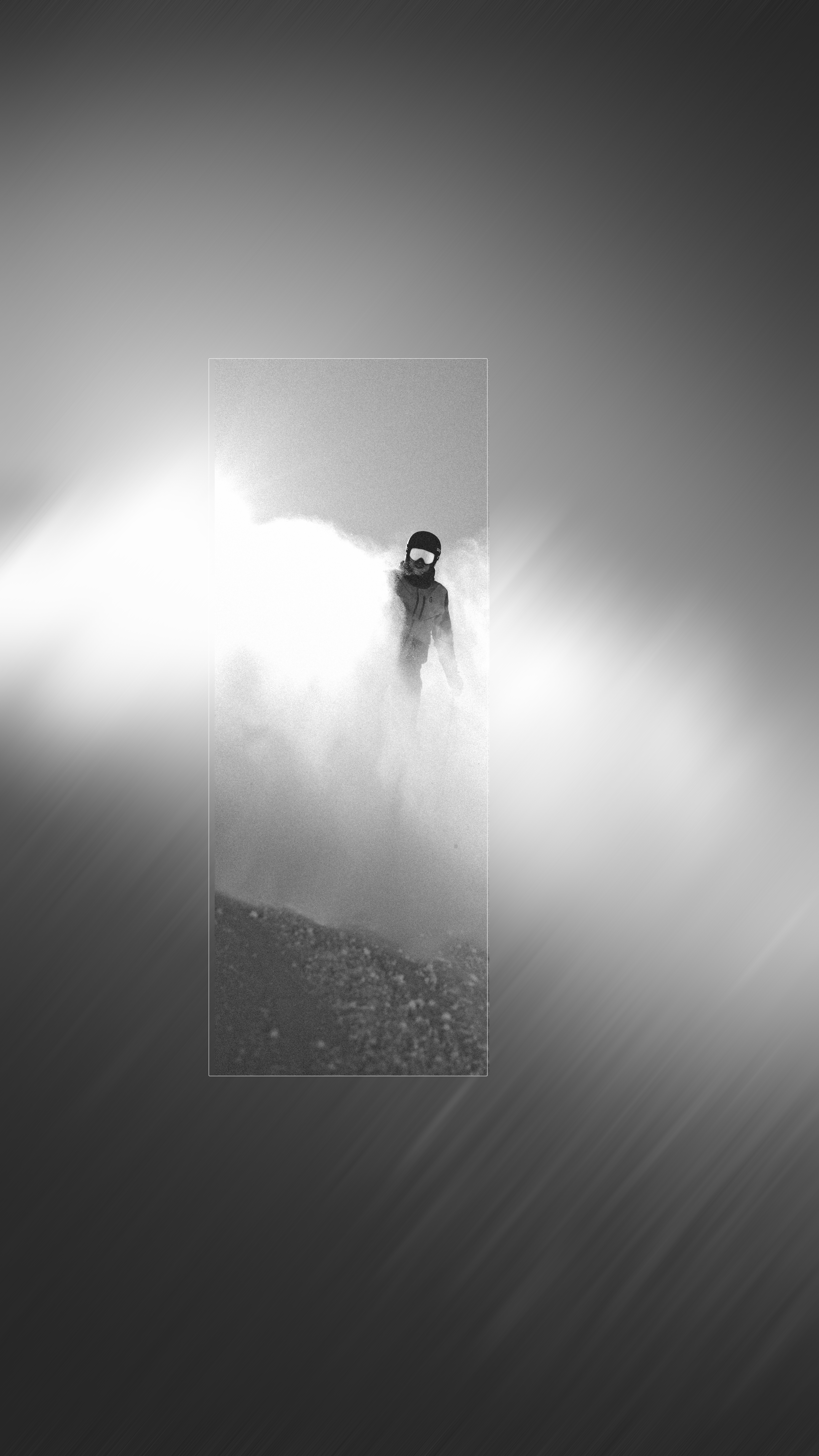 Schwarz-Weiß-Aufnahme eines Skifahrers im Powder